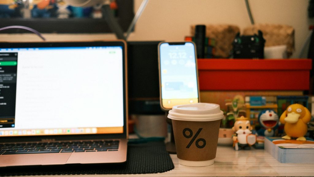 a cup of coffee sitting next to a laptop computer