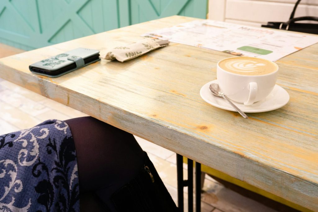 a cup of coffee sitting on top of a wooden table