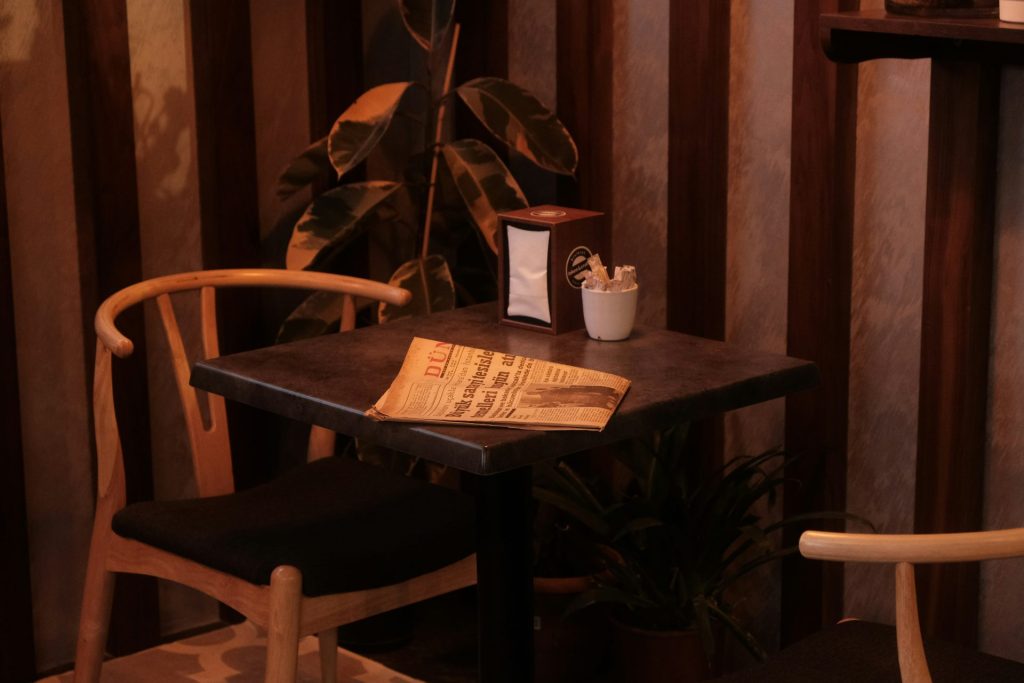 a table with a newspaper and a cup of coffee on it